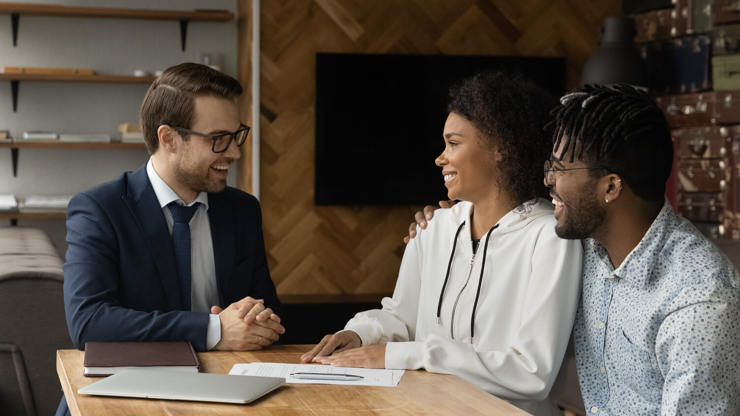 A couple happily interacting with a professional, discussing plans