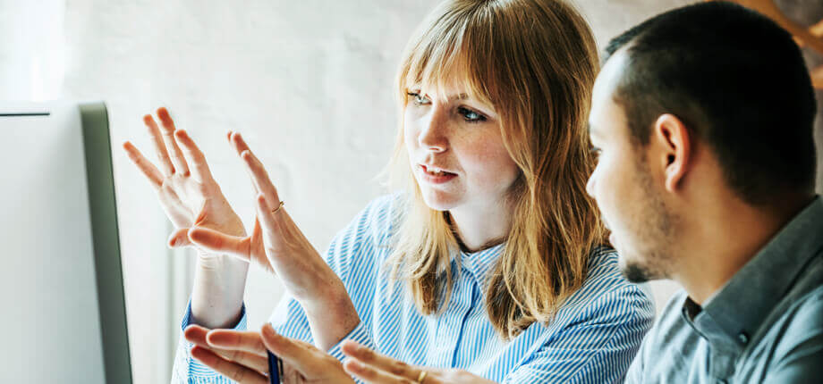 Male and female colleagues problem solving looking at a computer screen