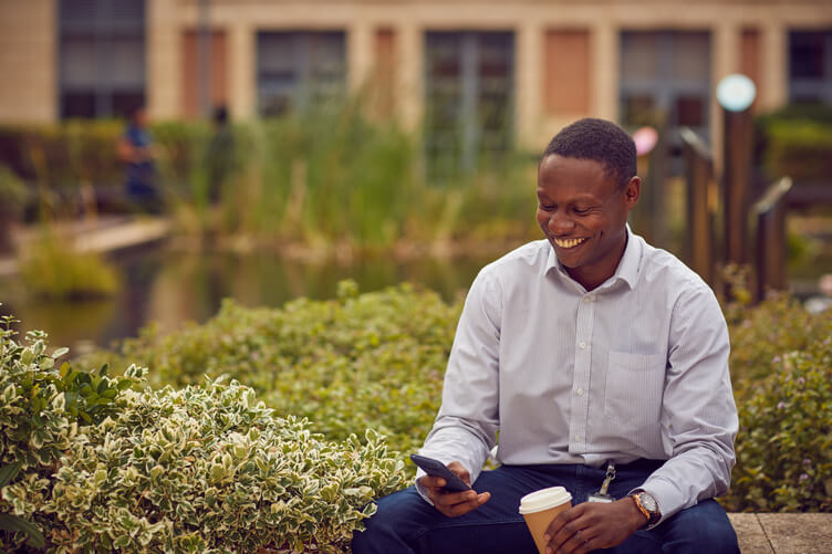 Man sitting in a courtyard surrounded by vegetation